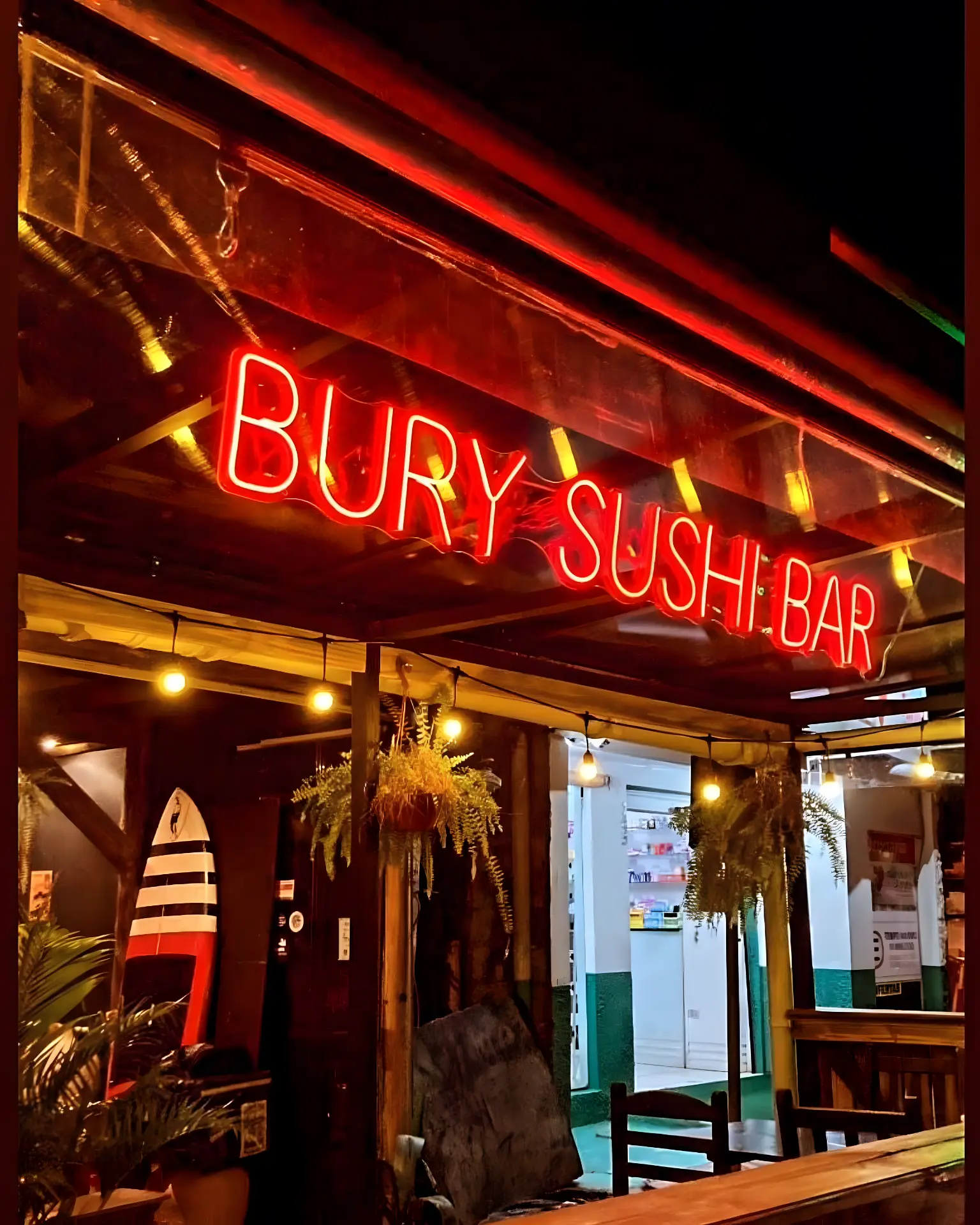 Fachada iluminada em neon vermelho do Bury Sushi Bar